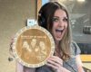 Smiling woman in a radio studio wearing headphones, holding a circular wooden plaque for Milwaukee's Hometown Morning Show.